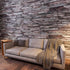 Modern sofa set against a realistic Gemstone 3D faux stone wall panel with rustic grey and brown textures.